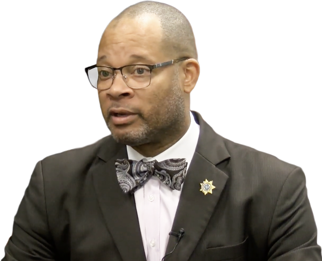 Aaron Ford in a bowtie against a rising line graph that illustrates increased spending
